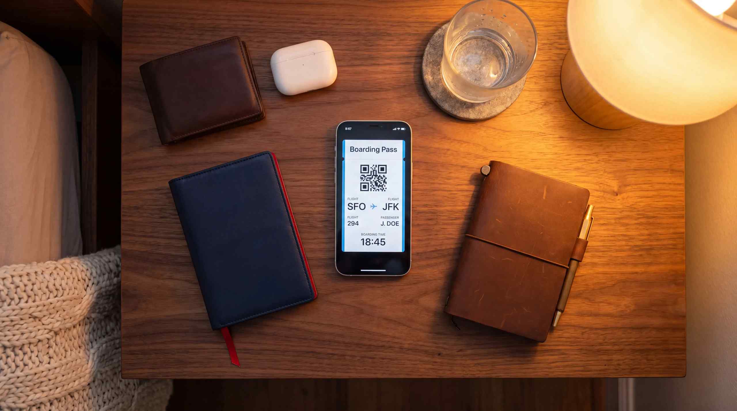 A collection of items useful for traveling including smartphone, AirPods and wallet.